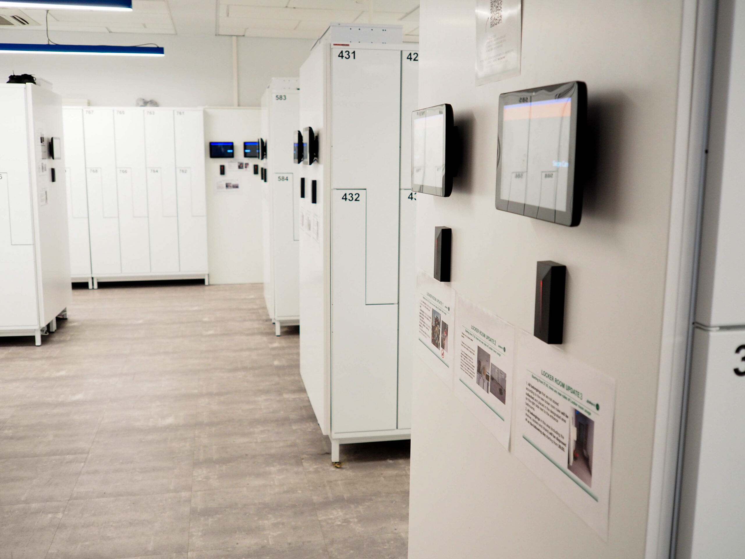 FoxSec smart locker client room with electronic access readers and touchscreen displays on white lockers