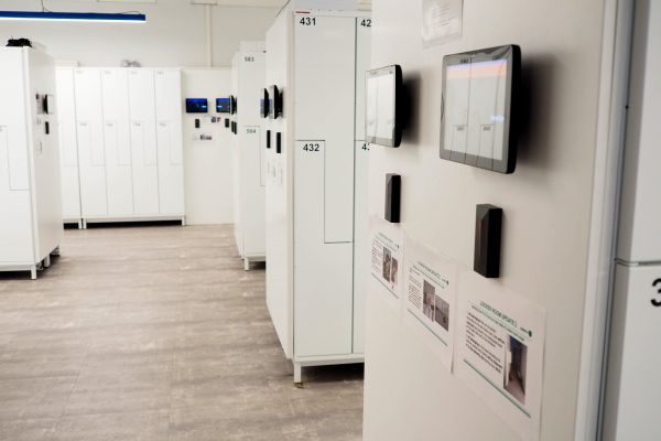 FoxSec smart locker client room with electronic access readers and touchscreen displays on white lockers